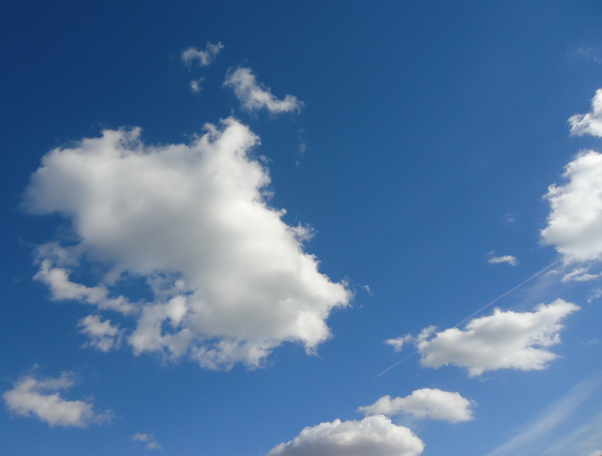 Deep blue sky with scattered white clouds